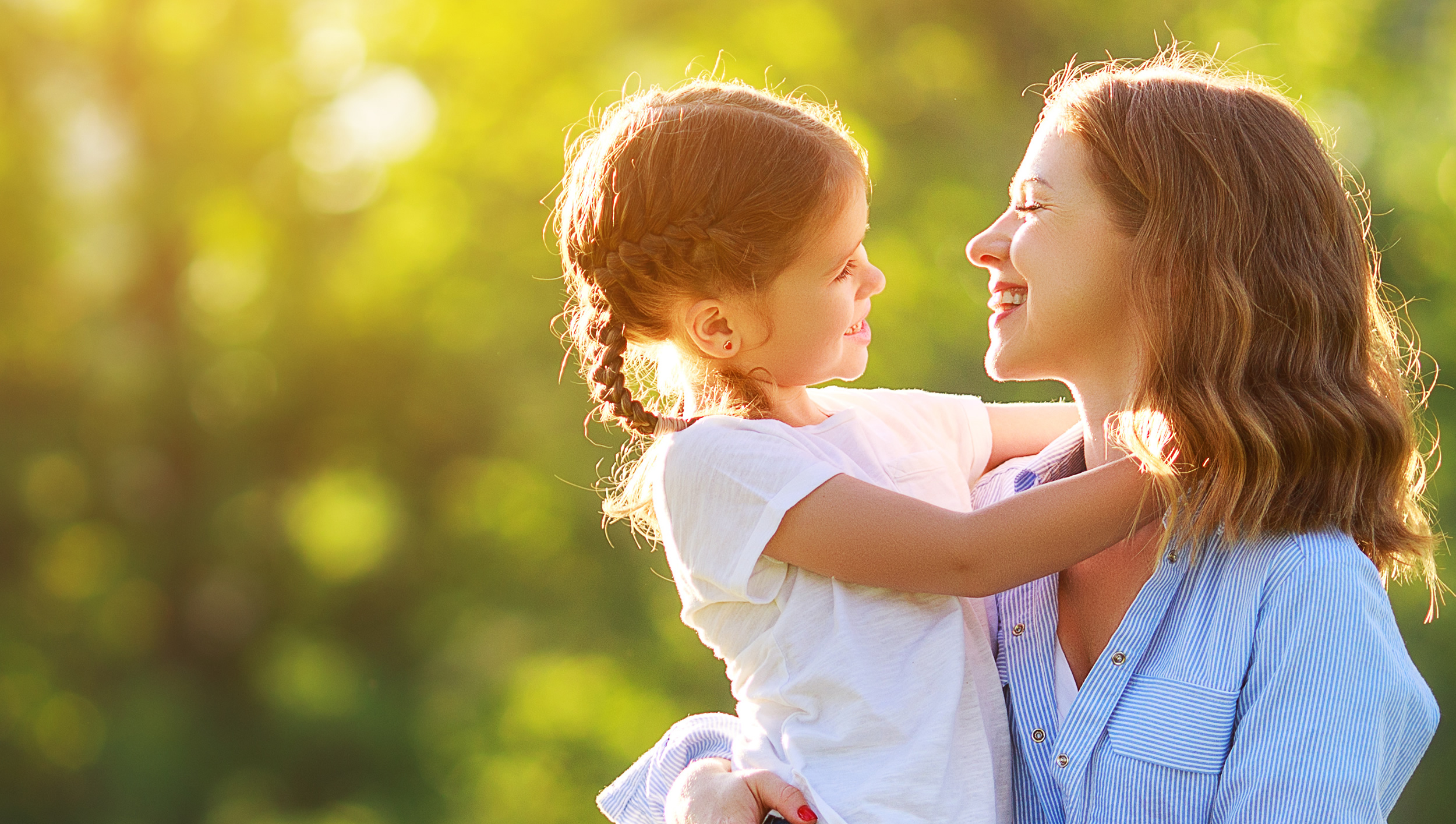 Mother and daughter smiling together outdoors